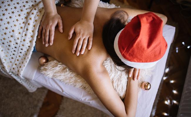 Girl in Christmas hat getting a massage.