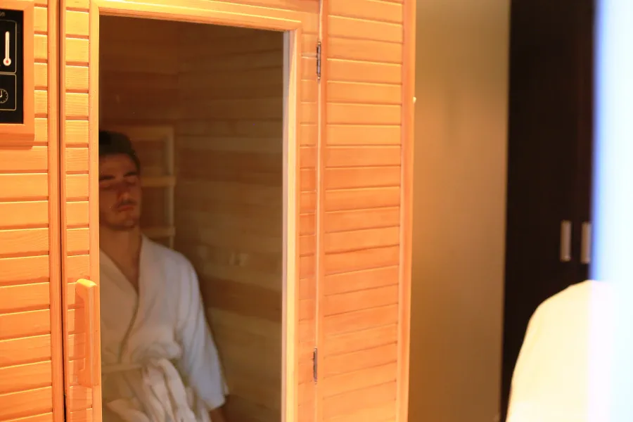 Client relaxing inside infrared sauna cabin at Massage Eden Auckland CBD
